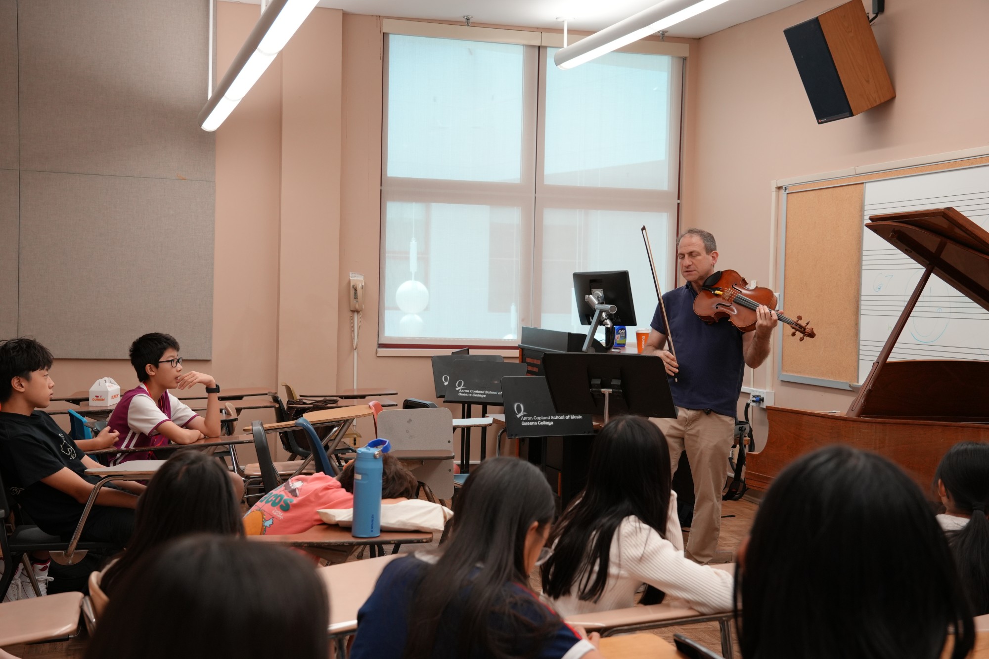 An OMI artist talks with young musicians during a class