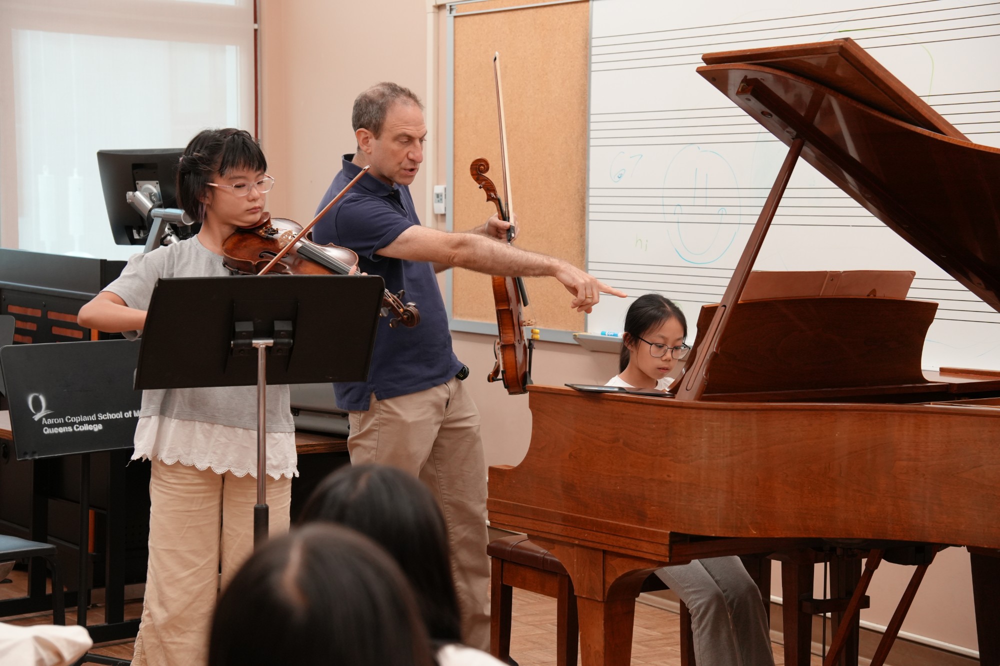 A faculty member coaches a student violin and piano duo