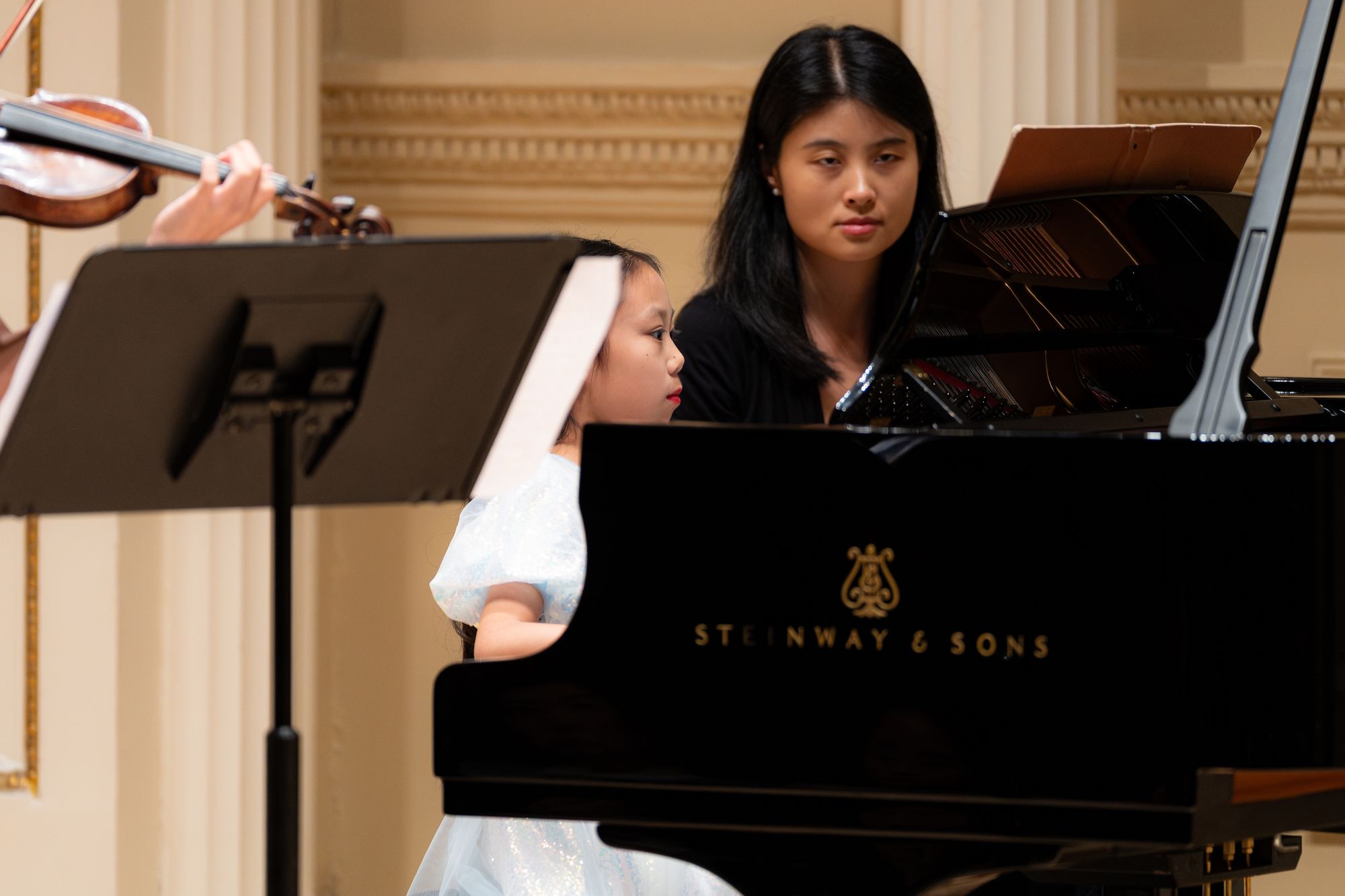 A young student watches a pianist during the concert