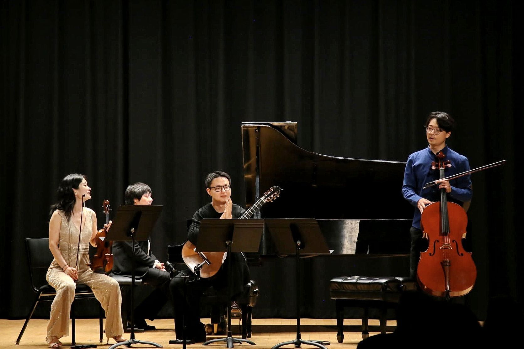 Mo Mo speaks to the audience as Qianwen Shen, Yinfei Wang, and Junhong Kuang look on