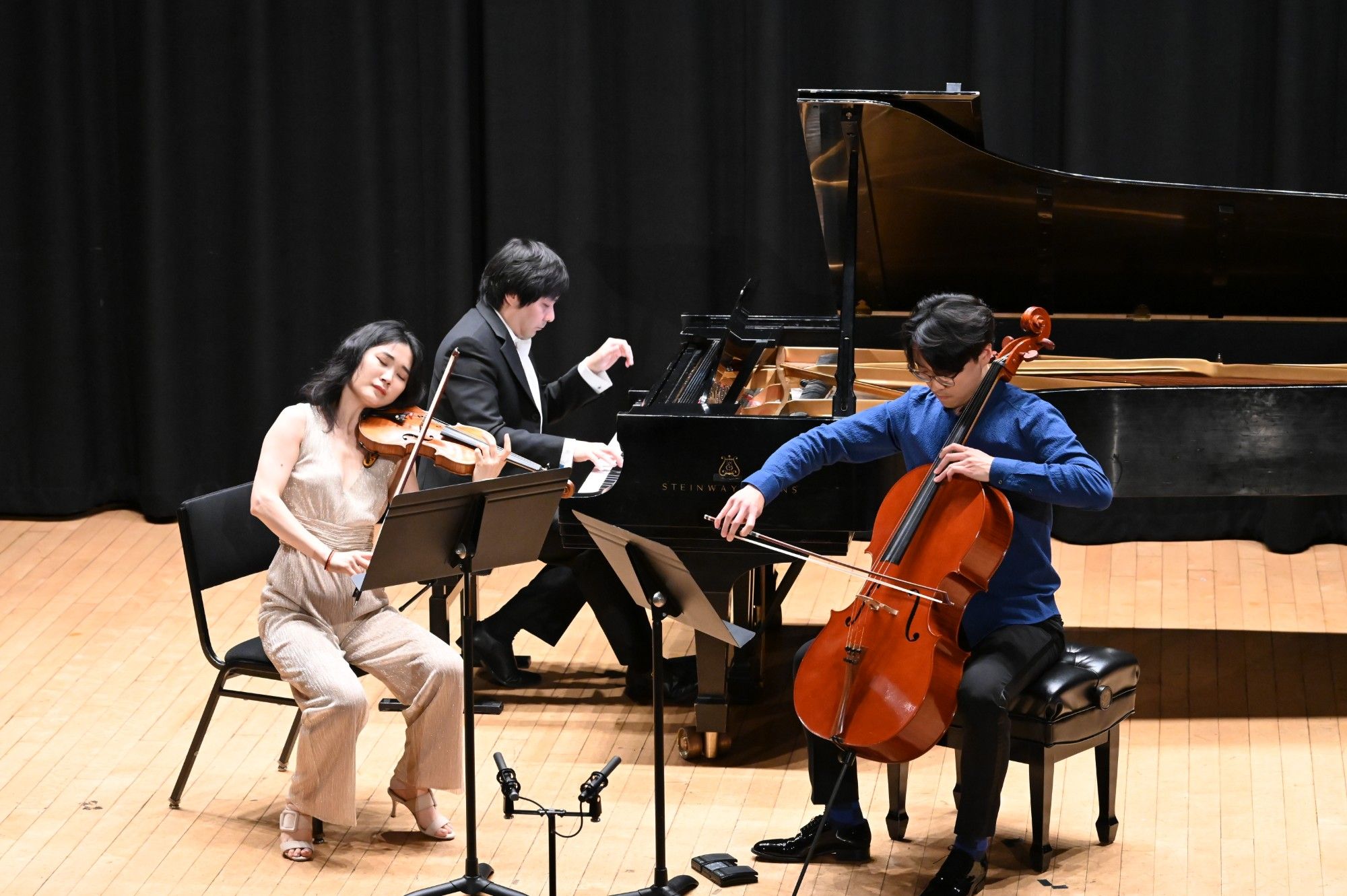 Qianwen Shen plays with eyes closed as Yinfei Wang and Mo Mo perform beside her