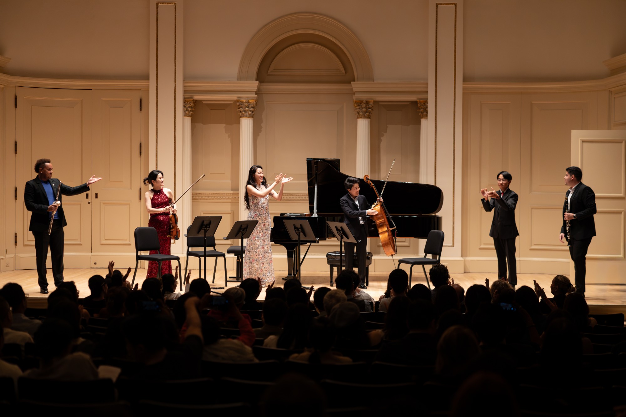 The performers and a young composer share the applause after a premiere
