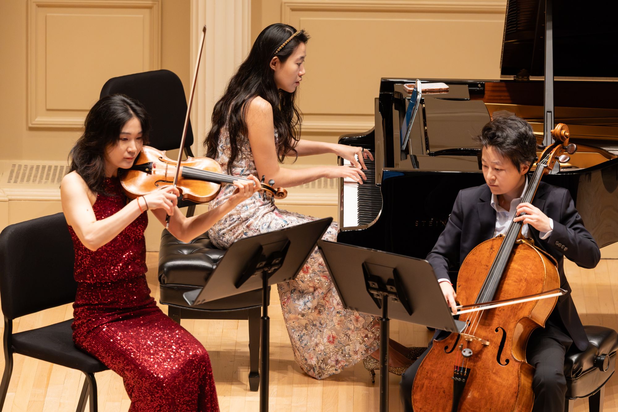 Violinist, pianist, and cellist in close-up mid-phrase