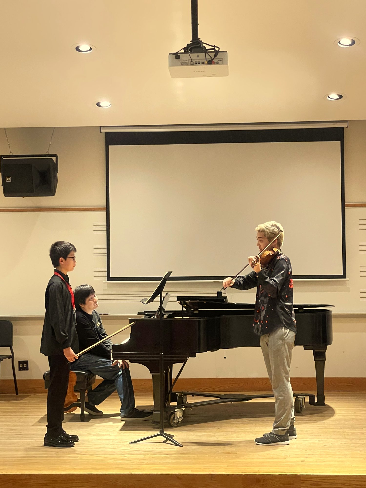 A violinist shares music with young students
