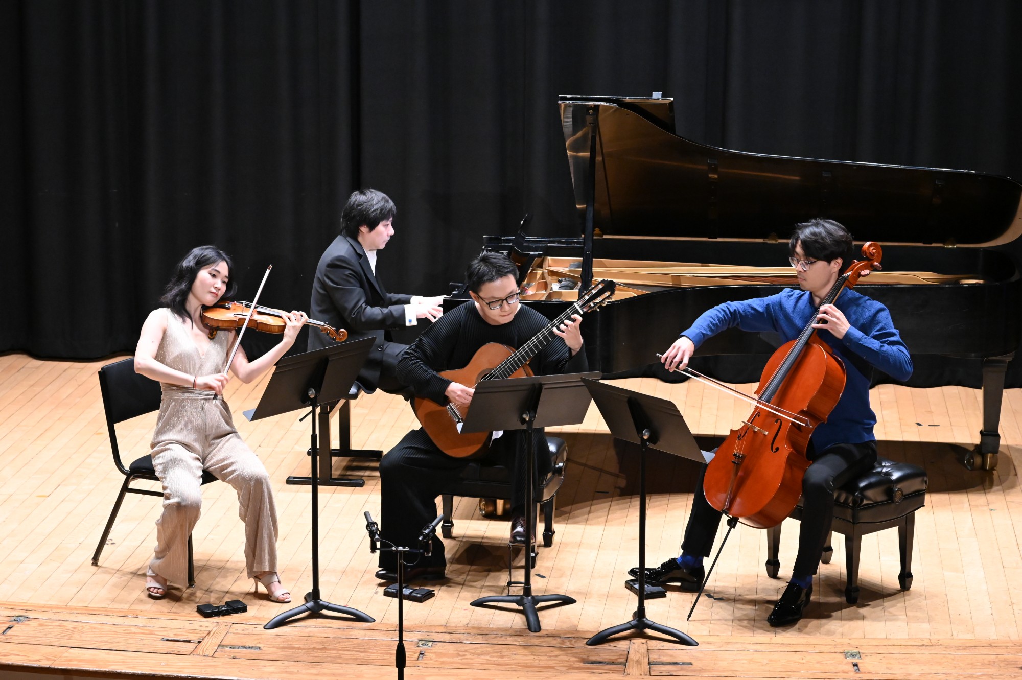 OMI artists perform with a guitarist on a partner stage